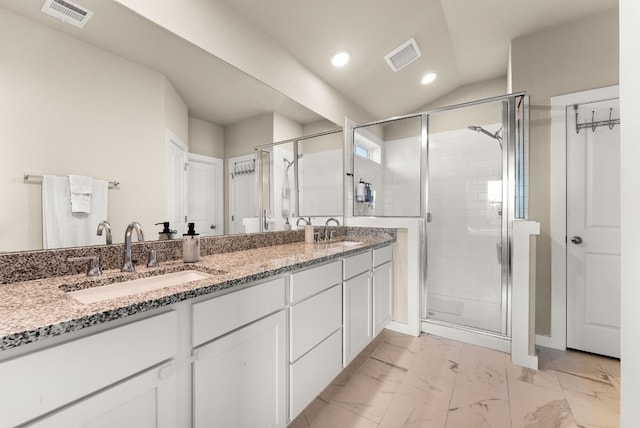 bathroom featuring vanity and a shower with door