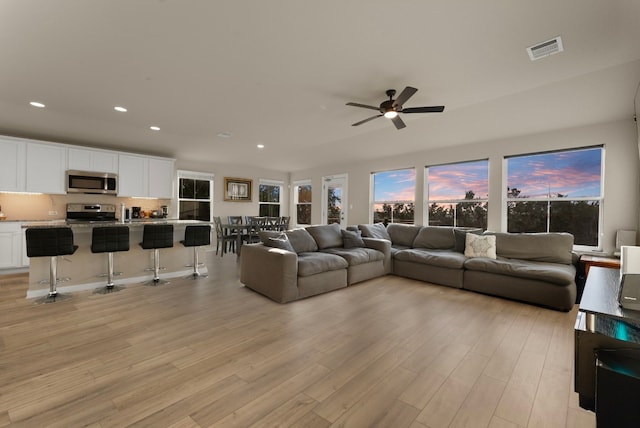 living room featuring ceiling fan and light hardwood / wood-style floors