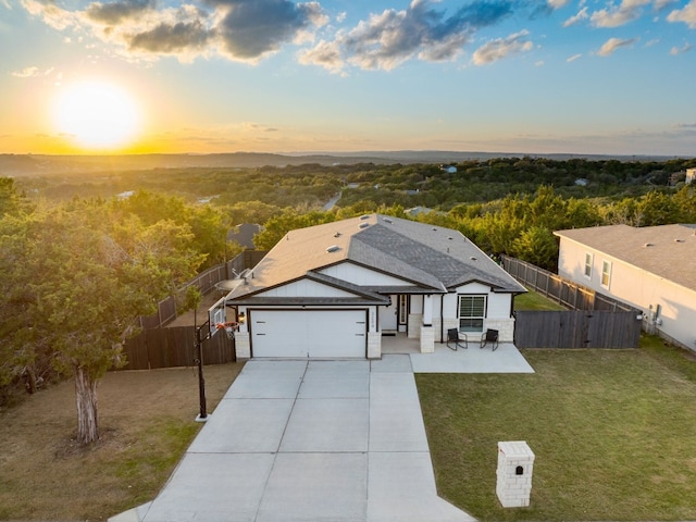 view of front of property with a patio, a garage, and a lawn