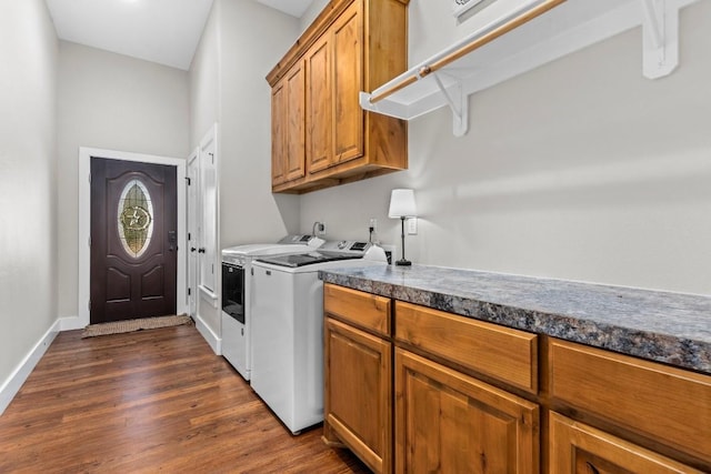 laundry room with washing machine and dryer, cabinets, and dark hardwood / wood-style floors