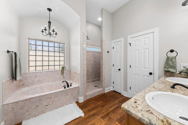 bathroom with hardwood / wood-style floors, vanity, separate shower and tub, and a chandelier