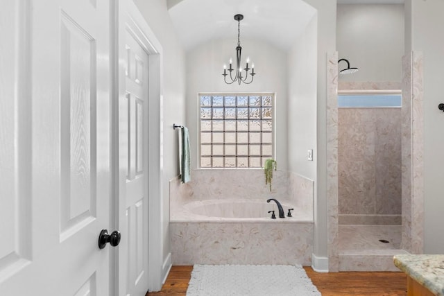 bathroom with separate shower and tub, hardwood / wood-style floors, lofted ceiling, and a notable chandelier