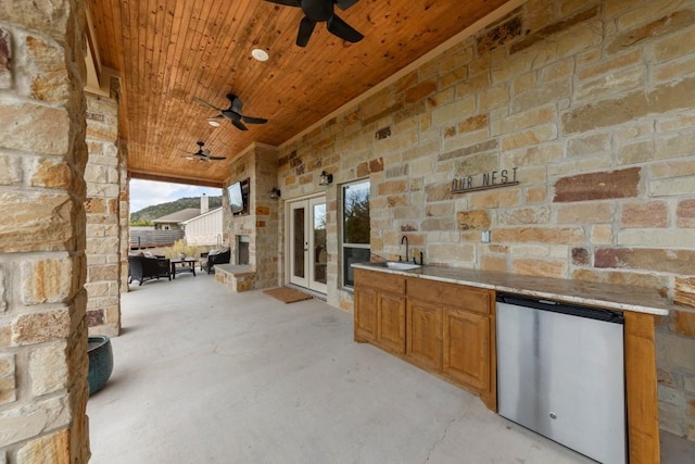 view of patio with ceiling fan, sink, and french doors