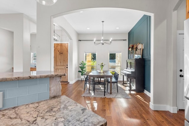 dining room with dark hardwood / wood-style floors and an inviting chandelier