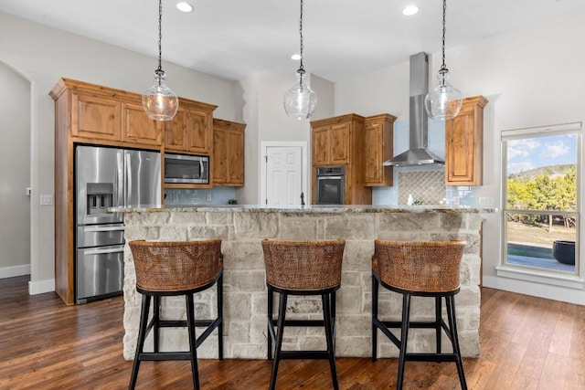 kitchen featuring backsplash, stainless steel appliances, a large island, and wall chimney range hood