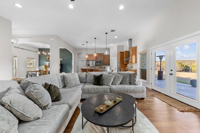 living room featuring a chandelier, wood-type flooring, and french doors