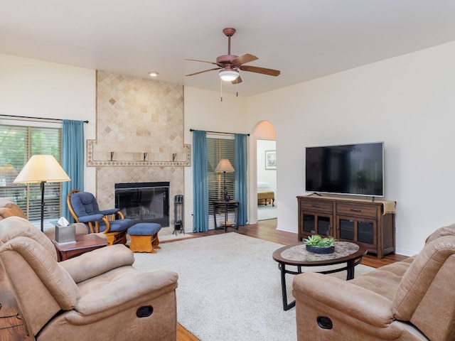 living room featuring ceiling fan, a fireplace, and light hardwood / wood-style flooring