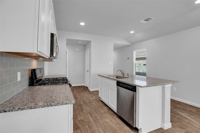 kitchen with a center island with sink, white cabinets, stainless steel appliances, and sink