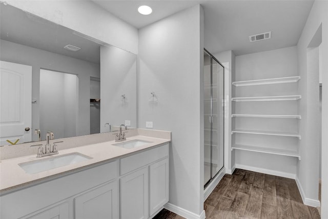 bathroom with wood-type flooring, vanity, and a shower with shower door