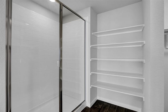 bathroom with wood-type flooring and an enclosed shower