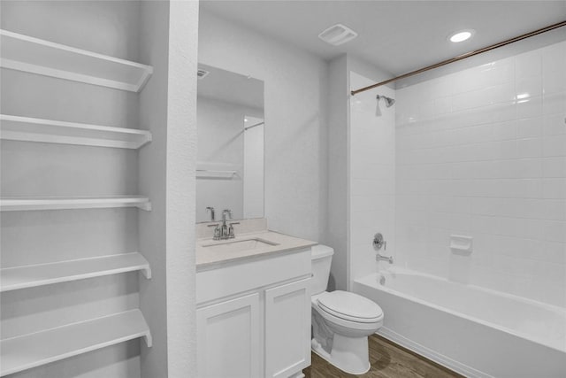 full bathroom featuring vanity, hardwood / wood-style flooring, toilet, and tiled shower / bath