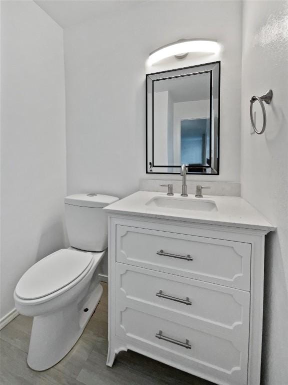 bathroom featuring hardwood / wood-style floors, vanity, and toilet