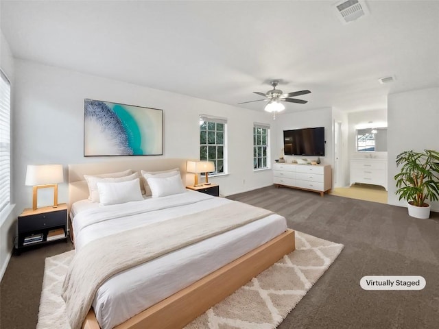 carpeted bedroom featuring ensuite bath and ceiling fan