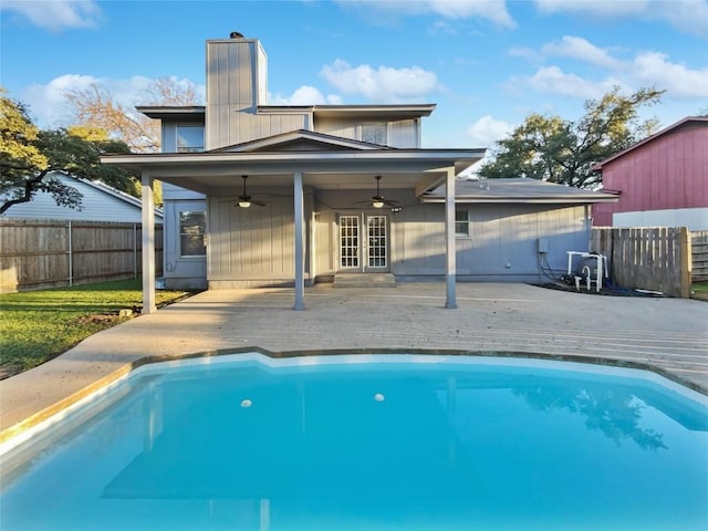 back of house with a fenced in pool, ceiling fan, and french doors