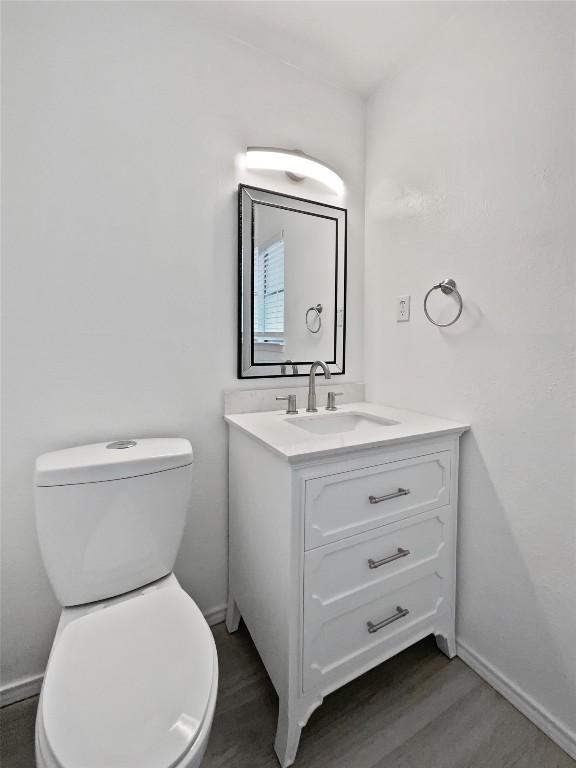 bathroom featuring vanity, wood-type flooring, and toilet