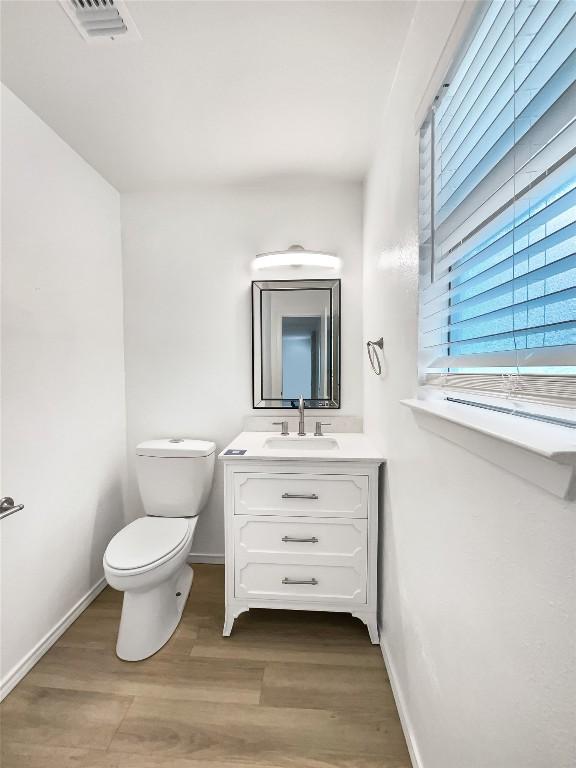 3424 Clarksburg Dr, Austin, TX 78745 - bathroom featuring toilet, vanity, baseboards, and wood finished floors