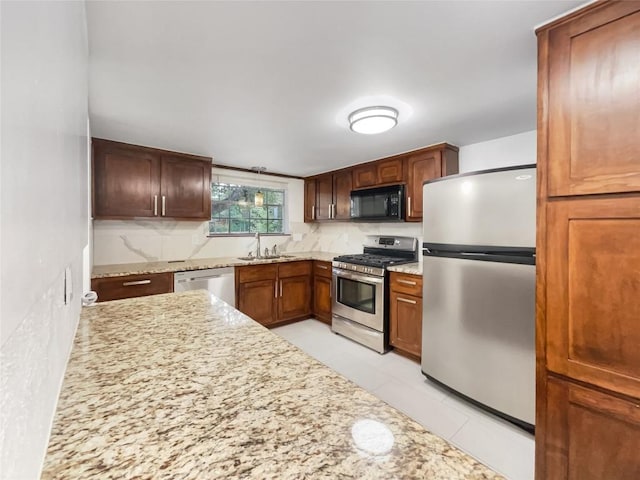 3424 Clarksburg Dr, Austin, TX 78745 - kitchen featuring stainless steel appliances, a sink, light stone counters, decorative backsplash, and light tile patterned floors