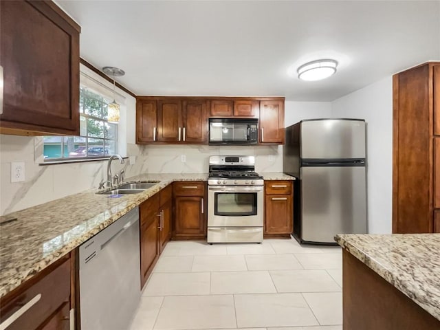 3424 Clarksburg Dr, Austin, TX 78745 - kitchen featuring stainless steel appliances, a sink, light stone countertops, light tile patterned floors, and decorative light fixtures
