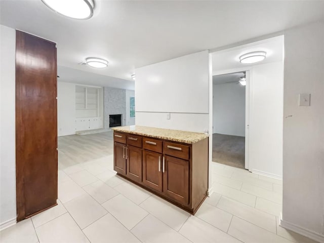 3424 Clarksburg Dr, Austin, TX 78745 - kitchen with a brick fireplace, a ceiling fan, baseboards, open floor plan, and light tile patterned floors