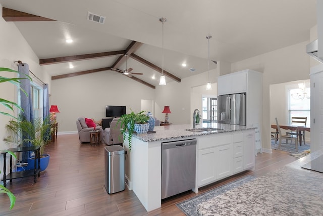 kitchen with white cabinetry, ceiling fan, stainless steel appliances, an island with sink, and decorative light fixtures