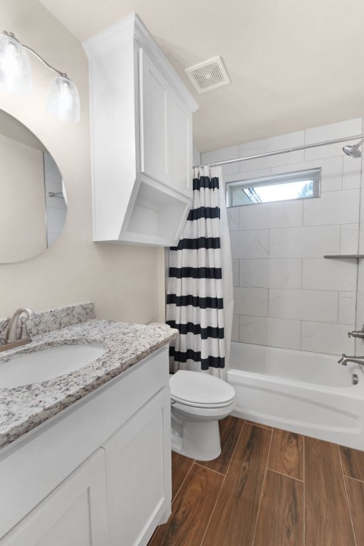 full bathroom with shower / bath combo with shower curtain, vanity, and toilet