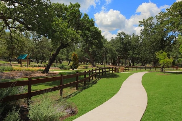 view of home's community featuring fence and a lawn