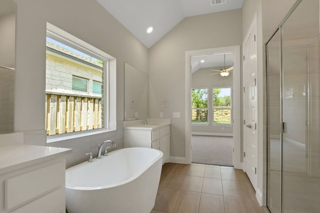 full bathroom featuring a shower stall, a soaking tub, vanity, and lofted ceiling