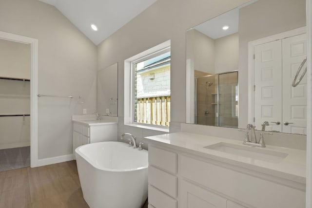 212 Millbend Rd, Georgetown, TX 78633 - bathroom featuring a stall shower, two vanities, a soaking tub, a walk in closet, and vaulted ceiling