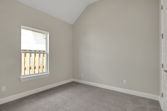 carpeted empty room with baseboards and lofted ceiling