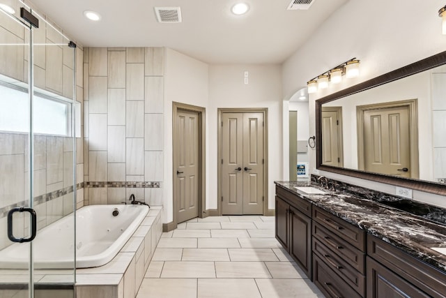 bathroom with plus walk in shower, tile patterned flooring, and vanity