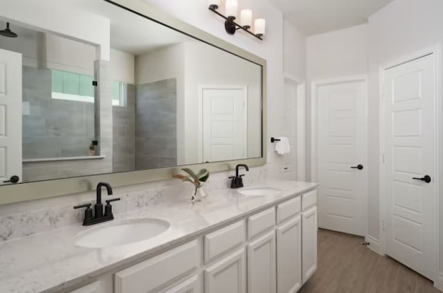 bathroom featuring a tile shower, hardwood / wood-style floors, and vanity