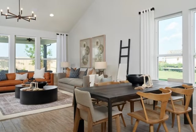 dining room featuring high vaulted ceiling, wood-type flooring, and a notable chandelier