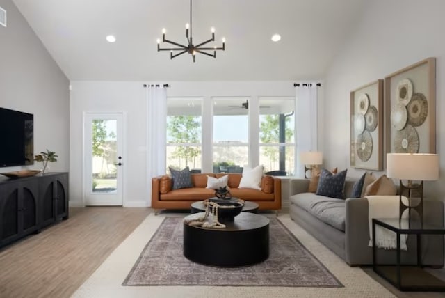 living room featuring light hardwood / wood-style flooring, an inviting chandelier, and lofted ceiling