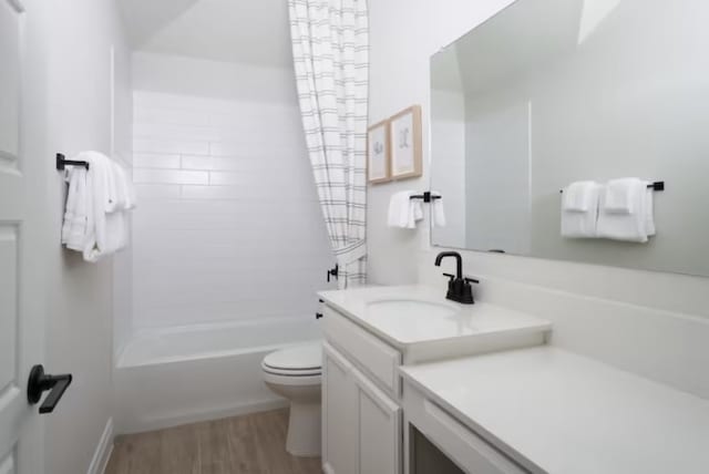 full bathroom featuring hardwood / wood-style floors, vanity,  shower combination, and toilet