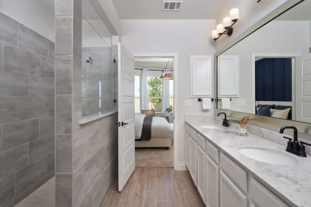 bathroom featuring a tile shower and vanity