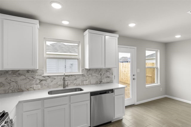 kitchen featuring white cabinetry, light hardwood / wood-style floors, stainless steel appliances, backsplash, and sink