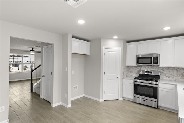 kitchen featuring ceiling fan, white cabinetry, decorative backsplash, and stainless steel appliances