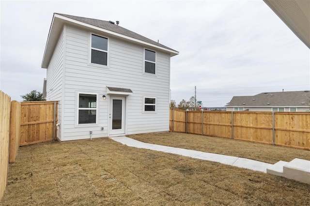 rear view of house featuring a lawn