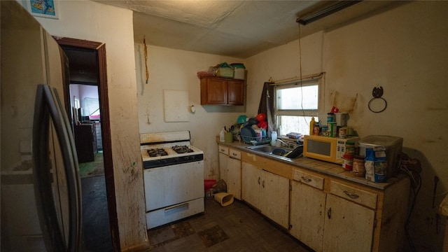 kitchen with tile countertops, white appliances, and sink