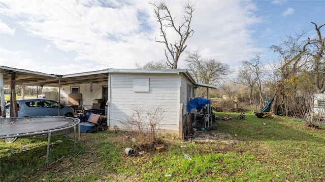 view of outdoor structure with a trampoline and a yard