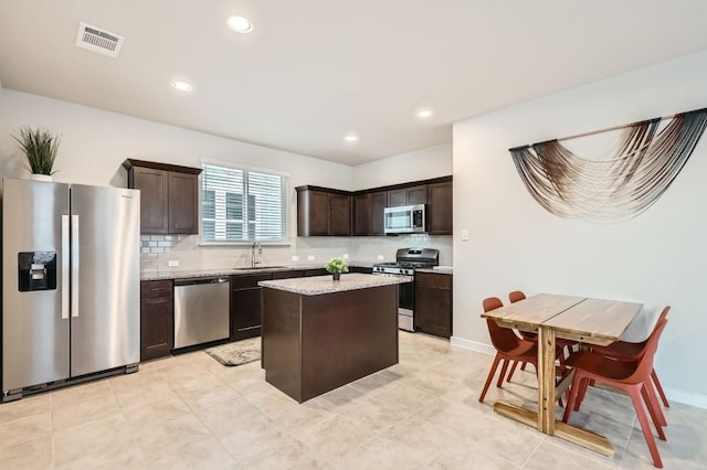 kitchen with dark brown cabinetry, decorative backsplash, a center island, and stainless steel appliances