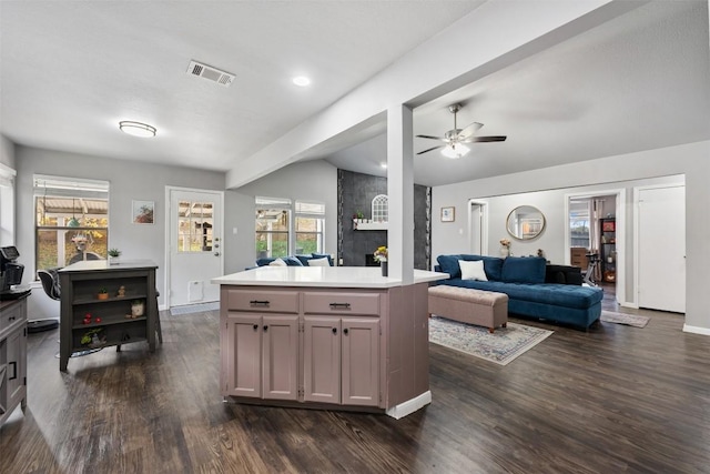 kitchen featuring dark hardwood / wood-style flooring, a center island, and ceiling fan