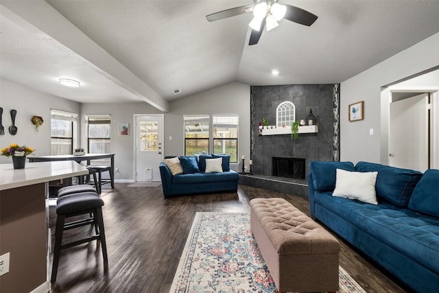 living room with ceiling fan, dark hardwood / wood-style flooring, plenty of natural light, and a tiled fireplace