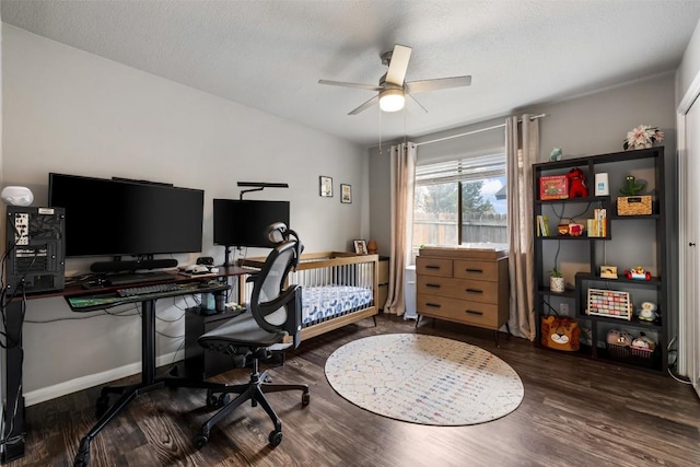 home office with ceiling fan, dark hardwood / wood-style flooring, and a textured ceiling