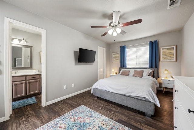 bedroom featuring ceiling fan, sink, ensuite bathroom, and dark hardwood / wood-style floors