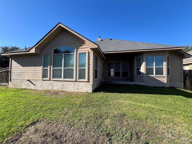 rear view of property with a lawn