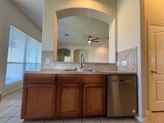 kitchen featuring decorative backsplash, ceiling fan, sink, light tile patterned floors, and dishwasher