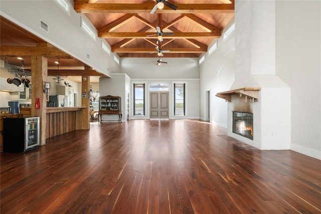 unfurnished living room with beamed ceiling, high vaulted ceiling, wooden ceiling, and hardwood / wood-style flooring