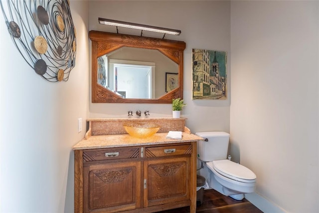 bathroom featuring hardwood / wood-style flooring, vanity, and toilet