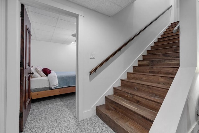 stairs with a paneled ceiling